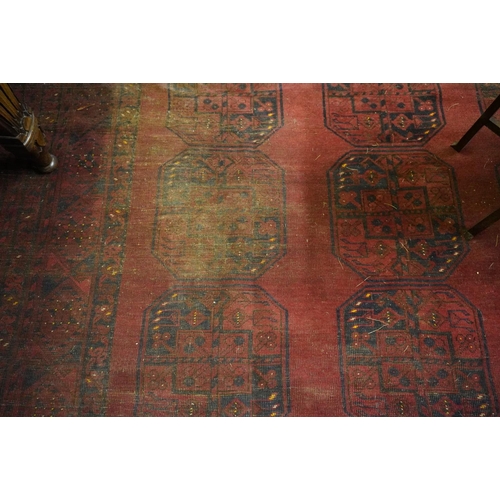 592 - Red ground Turkamen carpet with central field decorated with three rows of seven gul and multi-borde... 