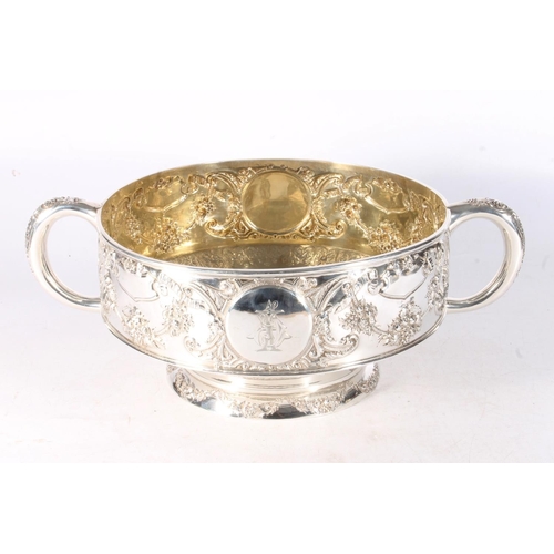 62 - Victorian silver twin handled punch bowl with gilded interior and embossed ornate designs of garland... 