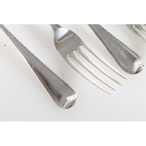 68 - Harlequin set of five silver table forks with bright cut borders, various makers, 318g.