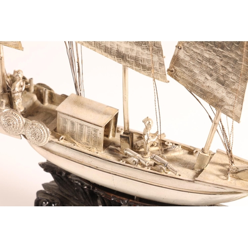 125 - Oriental white metal model of a triple masted sailing boat or junk, raised on carved wooden stand, 6... 