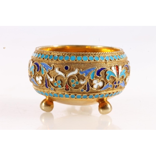 144 - Russian 84zl grade silver gilt and enamel salt cellar of hemi spherical form raised on three ball fe... 