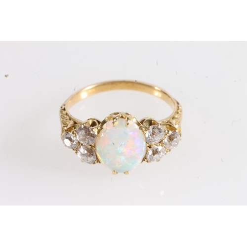 178 - Unmarked yellow metal opal and diamond seven stone ring, the large oval opal flanked by trios of 0.1... 