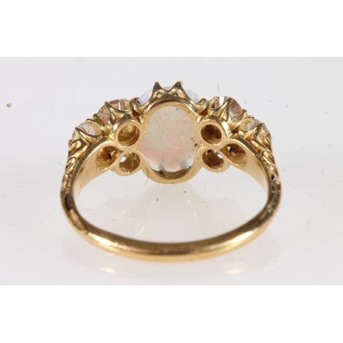 178 - Unmarked yellow metal opal and diamond seven stone ring, the large oval opal flanked by trios of 0.1... 