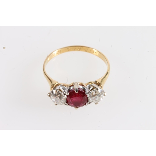 179 - Unmarked yellow metal ruby and diamond three stone ring, the central faceted oval ruby flanked by ~0... 