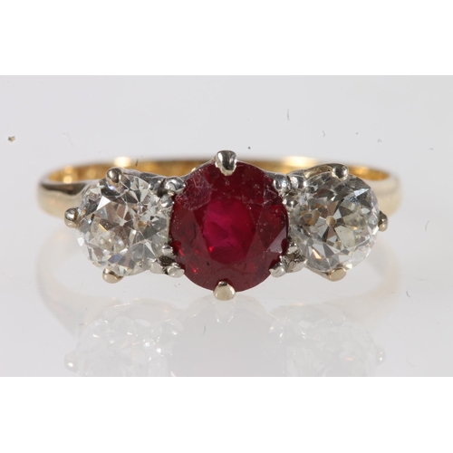 179 - Unmarked yellow metal ruby and diamond three stone ring, the central faceted oval ruby flanked by ~0... 