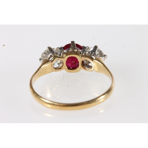 179 - Unmarked yellow metal ruby and diamond three stone ring, the central faceted oval ruby flanked by ~0... 