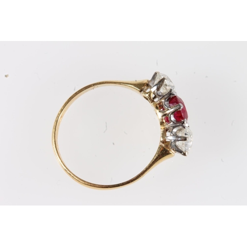 179 - Unmarked yellow metal ruby and diamond three stone ring, the central faceted oval ruby flanked by ~0... 