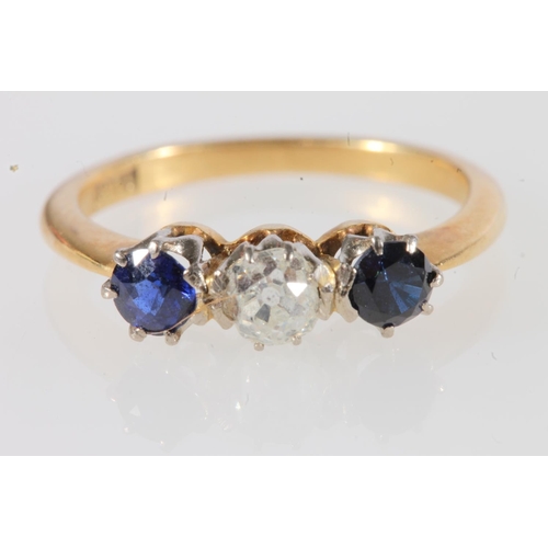 180 - 18ct gold diamond and sapphire three stone ring, the central 0.12ct diamond flanked by deep blue sap... 