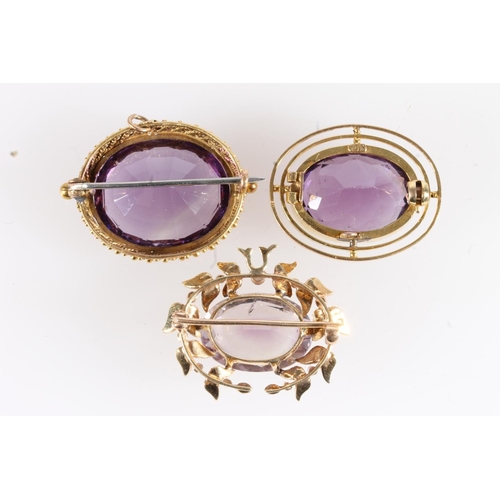 183 - Three gold mounted amethyst brooches, 19.4g gross.