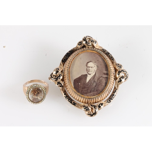 195 - Victorian yellow metal mourning brooch, the oval portrait of a seated gentleman framed by black enam... 