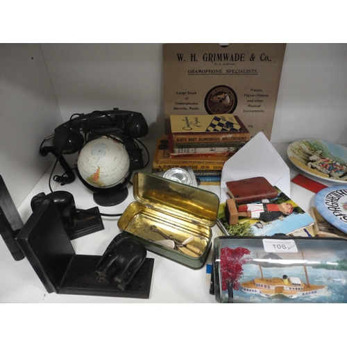 106 - Shelf lot of sundries to include ship in a bottle, telephone, playing cards, books, bookends etc