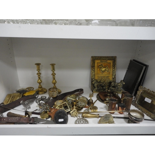 113 - Shelf lot of brass to include terrier bookends, candlesticks, ornaments, horse brasses etc.