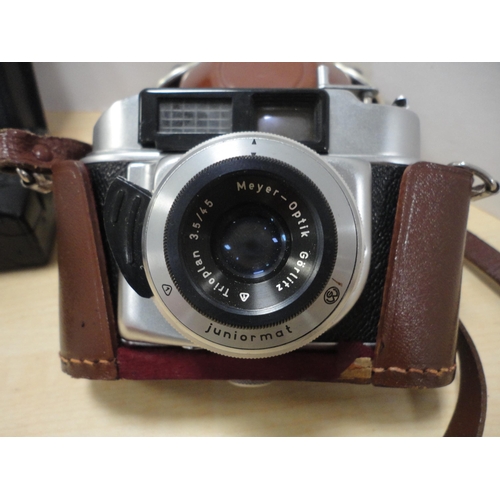 139 - Mantel clock with cased Canon camera and two others. (4)