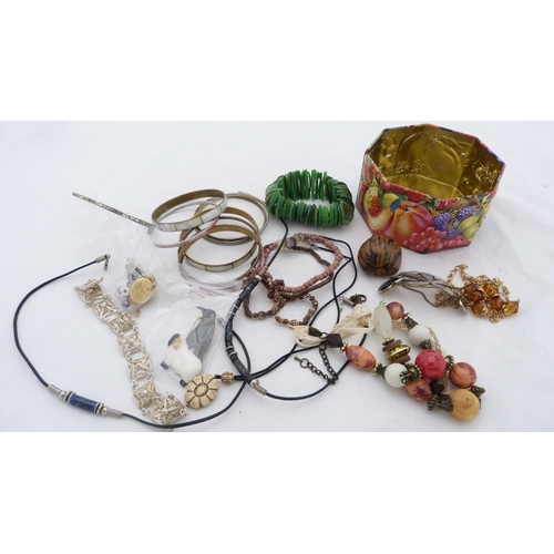 175 - Small tin containing miscellaneous costume jewellery to include bead necklaces, bangles, pendant etc... 