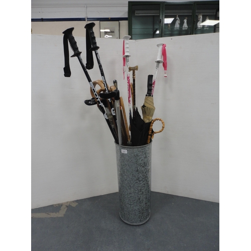 219 - Stick stand containing a quantity of walking sticks, parasols, umbrellas etc.