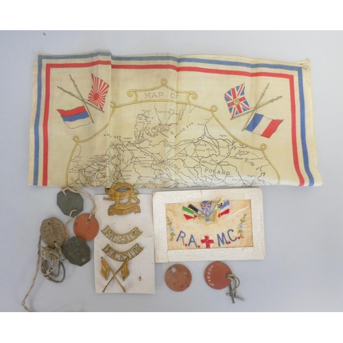 310 - WW1 militaria to include regimental badges, a Royal Army Medical Corps silk postcard, a WW1 map of E... 