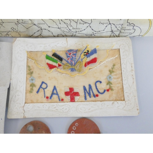 310 - WW1 militaria to include regimental badges, a Royal Army Medical Corps silk postcard, a WW1 map of E... 