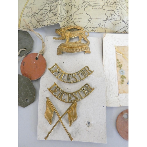 310 - WW1 militaria to include regimental badges, a Royal Army Medical Corps silk postcard, a WW1 map of E... 