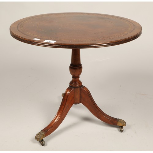 551 - Circular leather inlaid side table on paw feet and casters