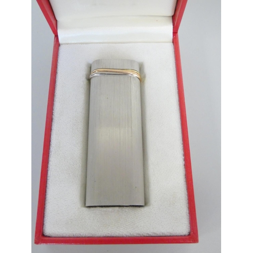 351 - Must de Cartier brushed steel and gold banded trilogy lighter serial number 96141V. Complete with bo... 