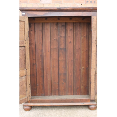 561 - Antique oak two door cupboard or wardrobe, raised on bun feet, 124cm wide.