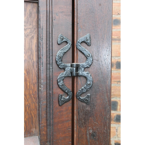 561 - Antique oak two door cupboard or wardrobe, raised on bun feet, 124cm wide.