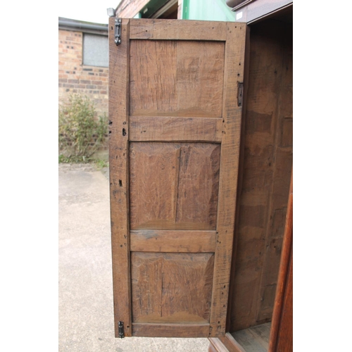 561 - Antique oak two door cupboard or wardrobe, raised on bun feet, 124cm wide.