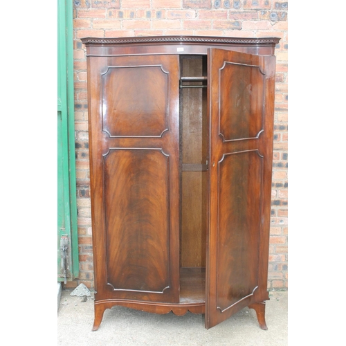 565 - 20th century mahogany serpentine fronted wardrobe, the cornice with Greek key frieze, raised on spla... 