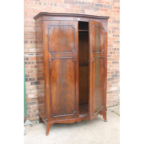 565 - 20th century mahogany serpentine fronted wardrobe, the cornice with Greek key frieze, raised on spla... 