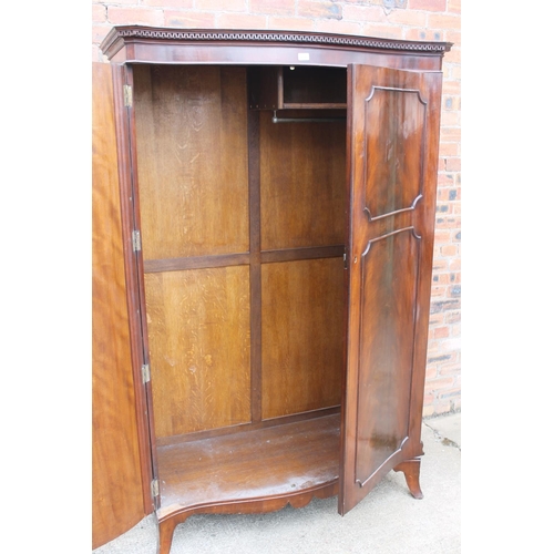 565 - 20th century mahogany serpentine fronted wardrobe, the cornice with Greek key frieze, raised on spla... 