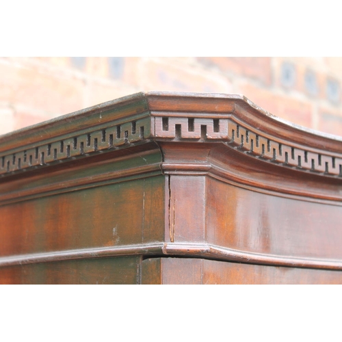 565 - 20th century mahogany serpentine fronted wardrobe, the cornice with Greek key frieze, raised on spla... 