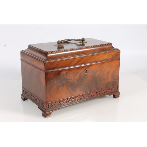 447 - 19th century flame mahogany tea caddy of casket form with fret carved band, raised on squat ogee bra... 