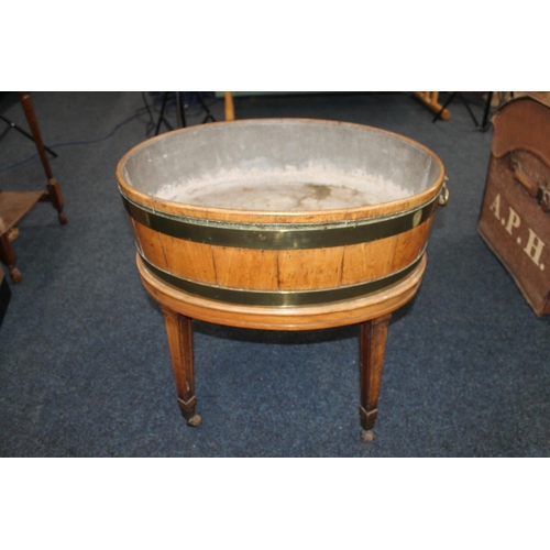 540 - Antique mahogany and inlaid oval cellarette wine cooler of coopered form with brass rungs, raised on... 