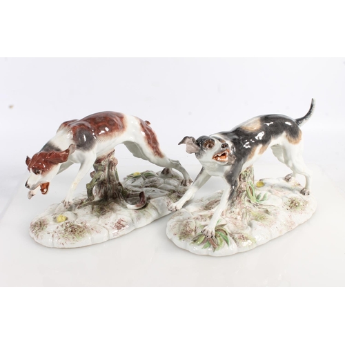 435 - Two 19th century Continental porcelain modesl of dogs, modelled bearing it teeth (af broken leg, the... 