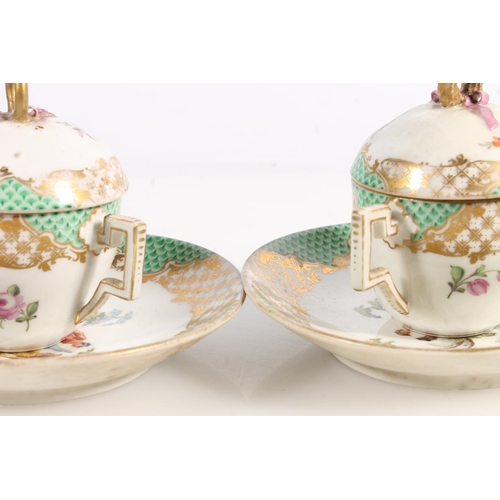 501 - Pair of Continental porcelain chocolate cups and covers on stands having green and gilt borders and ... 