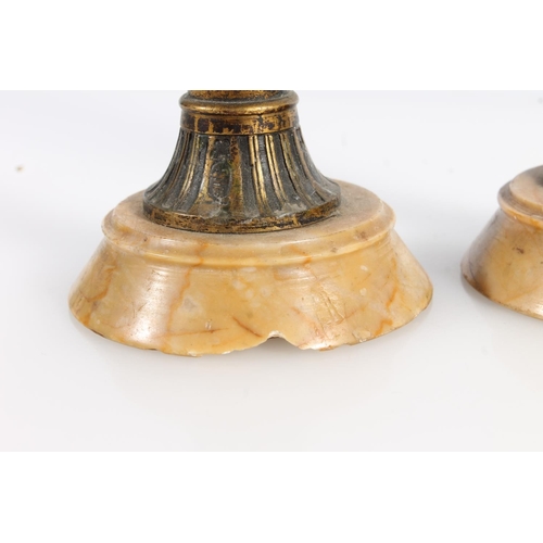 513 - Pair of Egyptian Revival gilt metal and marble candlesticks, 19cm tall.