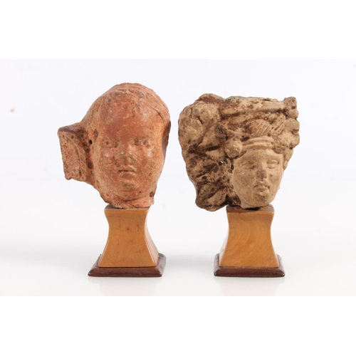 521 - Two Greco Roman miniature terracotta busts on squat stands, 8cm and 7cm tall. (2)