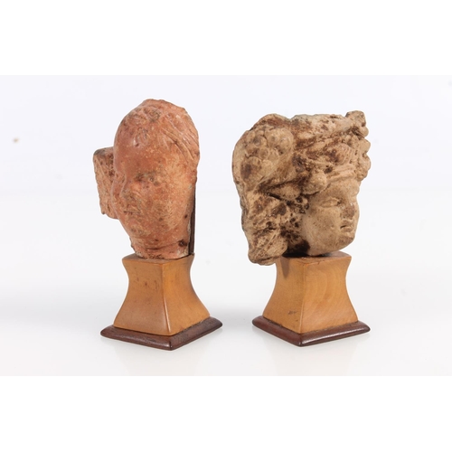 521 - Two Greco Roman miniature terracotta busts on squat stands, 8cm and 7cm tall. (2)