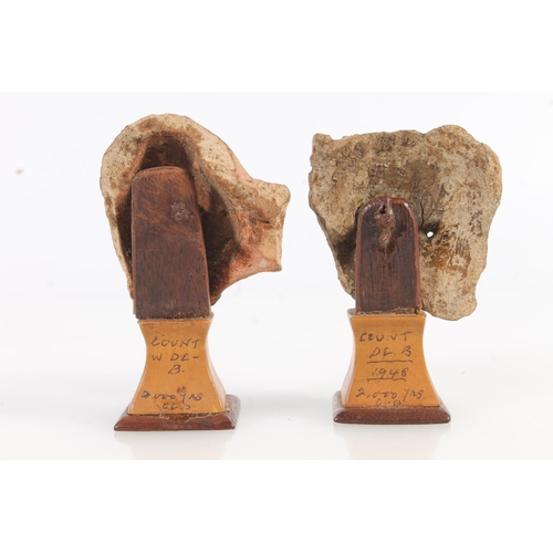 521 - Two Greco Roman miniature terracotta busts on squat stands, 8cm and 7cm tall. (2)