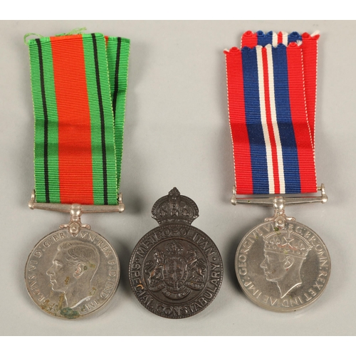 56 - WWII War and Defence medals, and a Metropolitan Special Constabulary bronze cap badge with W.O. Lewi... 