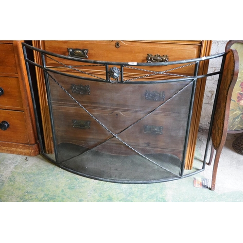 Large metal spit guard with lion ring handle to centre.