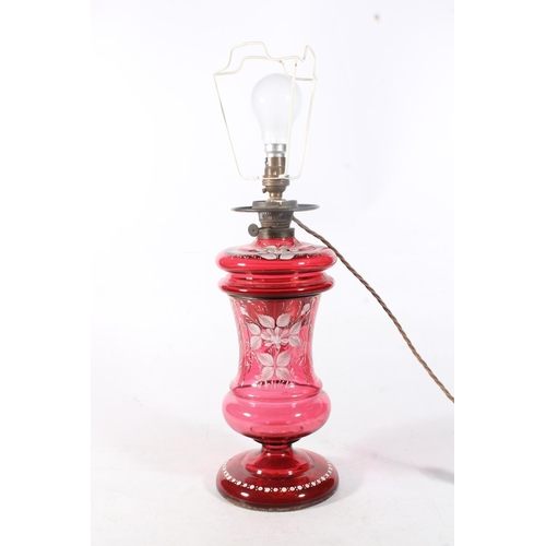 27 - Cranberry glass oil lamp decorated with white enamel flowers.