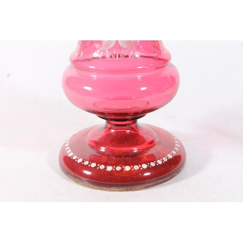 27 - Cranberry glass oil lamp decorated with white enamel flowers.