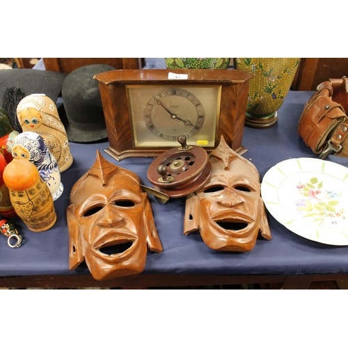 47 - Hamilton and Inches mantel clock, pair of African carved wall masks and a fishing reel.