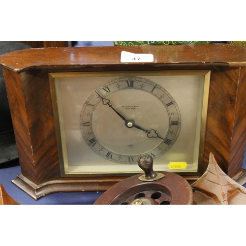 47 - Hamilton and Inches mantel clock, pair of African carved wall masks and a fishing reel.