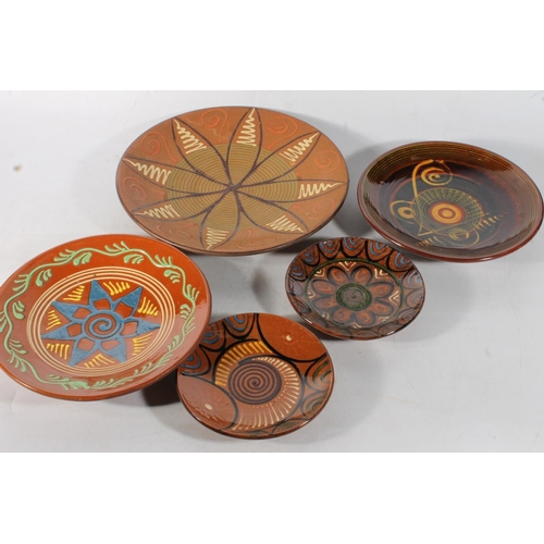 79 - Five Studio Pottery slip glazed Puigdemont wall plates, largest 35cm diameter.