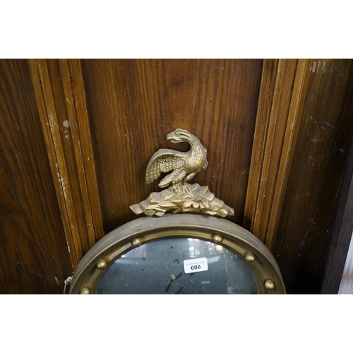 606 - Round gilt frame mirror with eagle crest, W38cm.