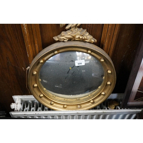 606 - Round gilt frame mirror with eagle crest, W38cm.