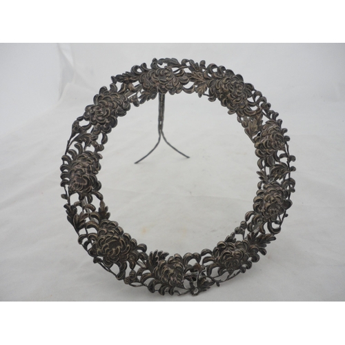 187 - White metal embossed circular photograph frame on an easel support stand.