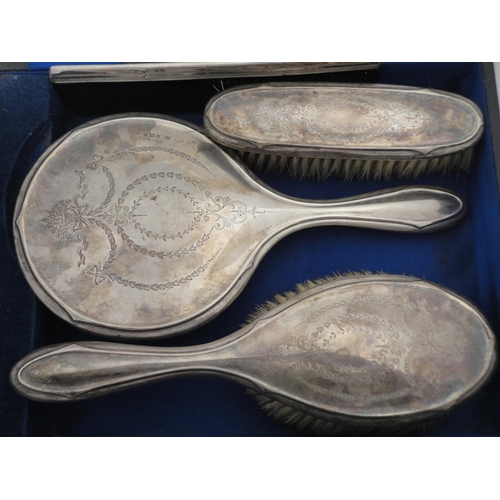 202 - Silver-backed four-piece dressing table set in fitted box.